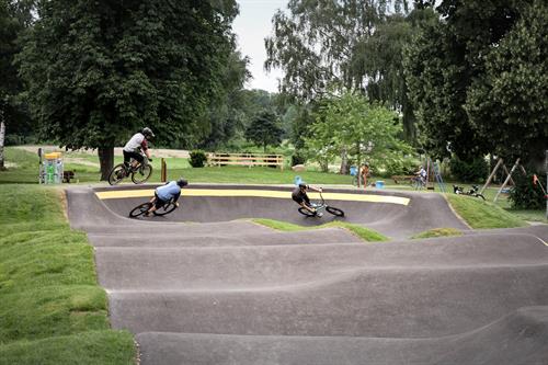 Eine Gruppe von Menschen, die auf einem asphaltierten Gelände Fahrrad fahren